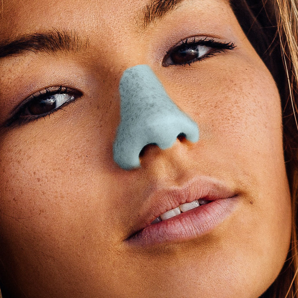 Light blue sunscreen on woman's nose.